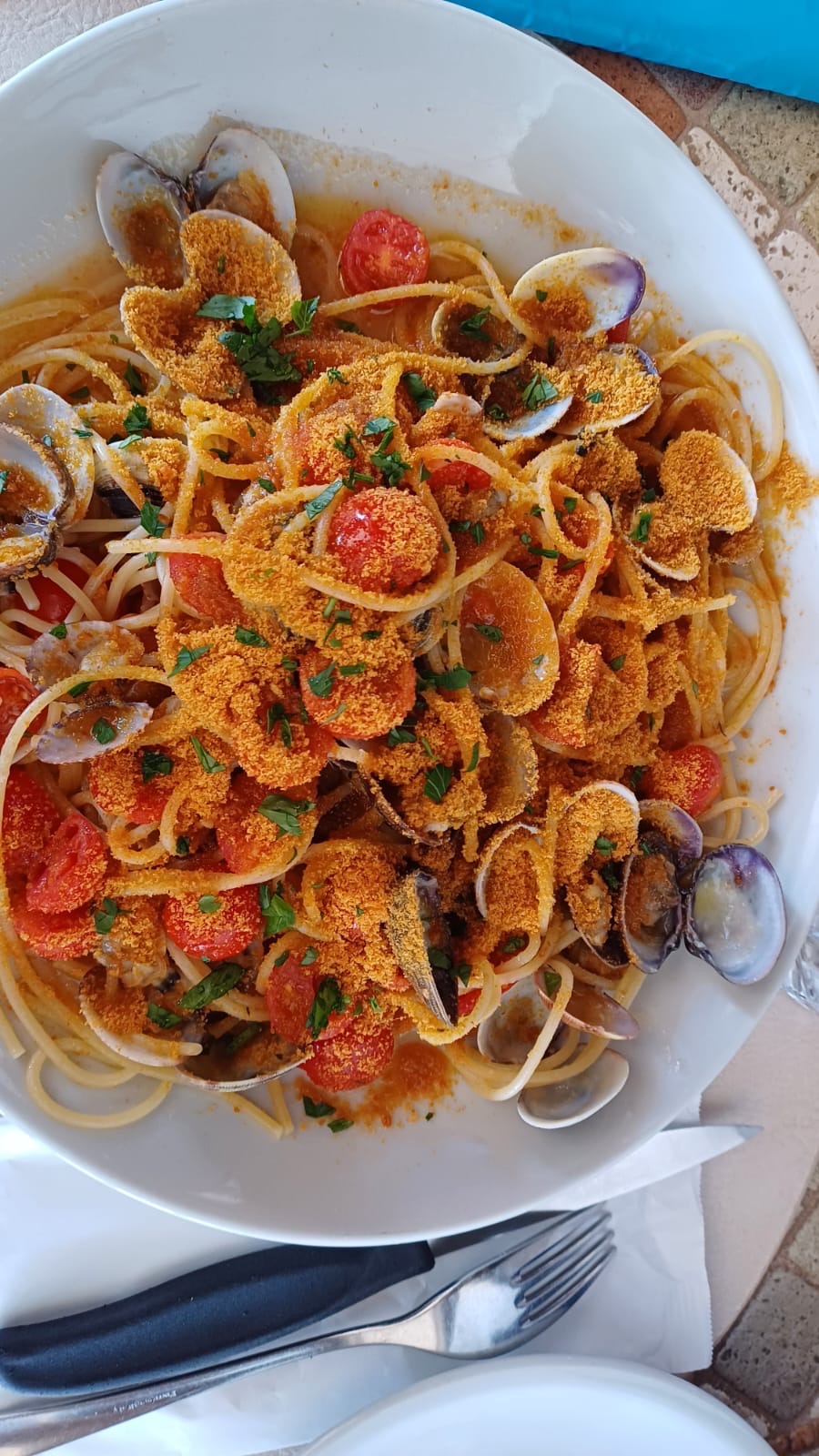 Spaghetti with clams, cherry tomatoes and breadcrumbs served in northeast Sardinia