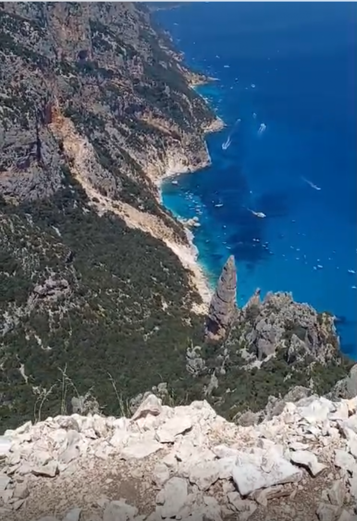 View of Cala Goloritzè and its distinctive limestone pinnacle from the hiking trail on the Baunei coast