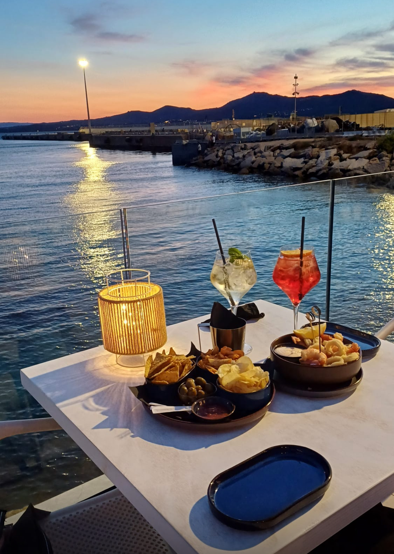 Waterfront aperitivo overlooking Golfo Aranci harbor at sunset