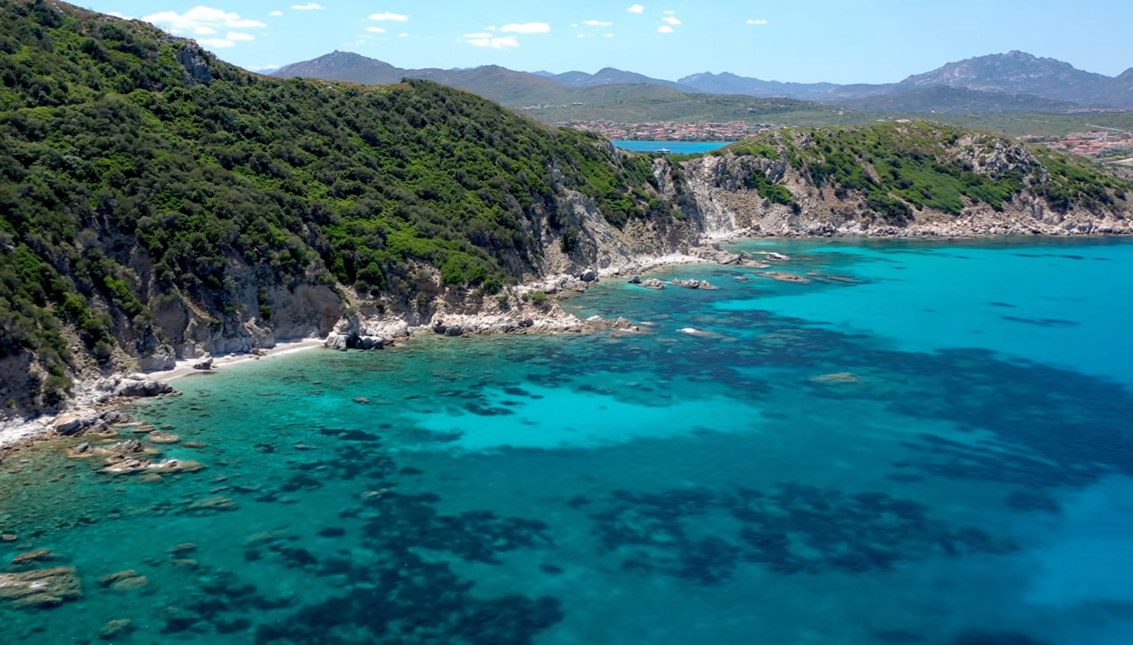 Aerial view of Capo Figari's rocky coastline and clear turquoise water near Golfo Aranci