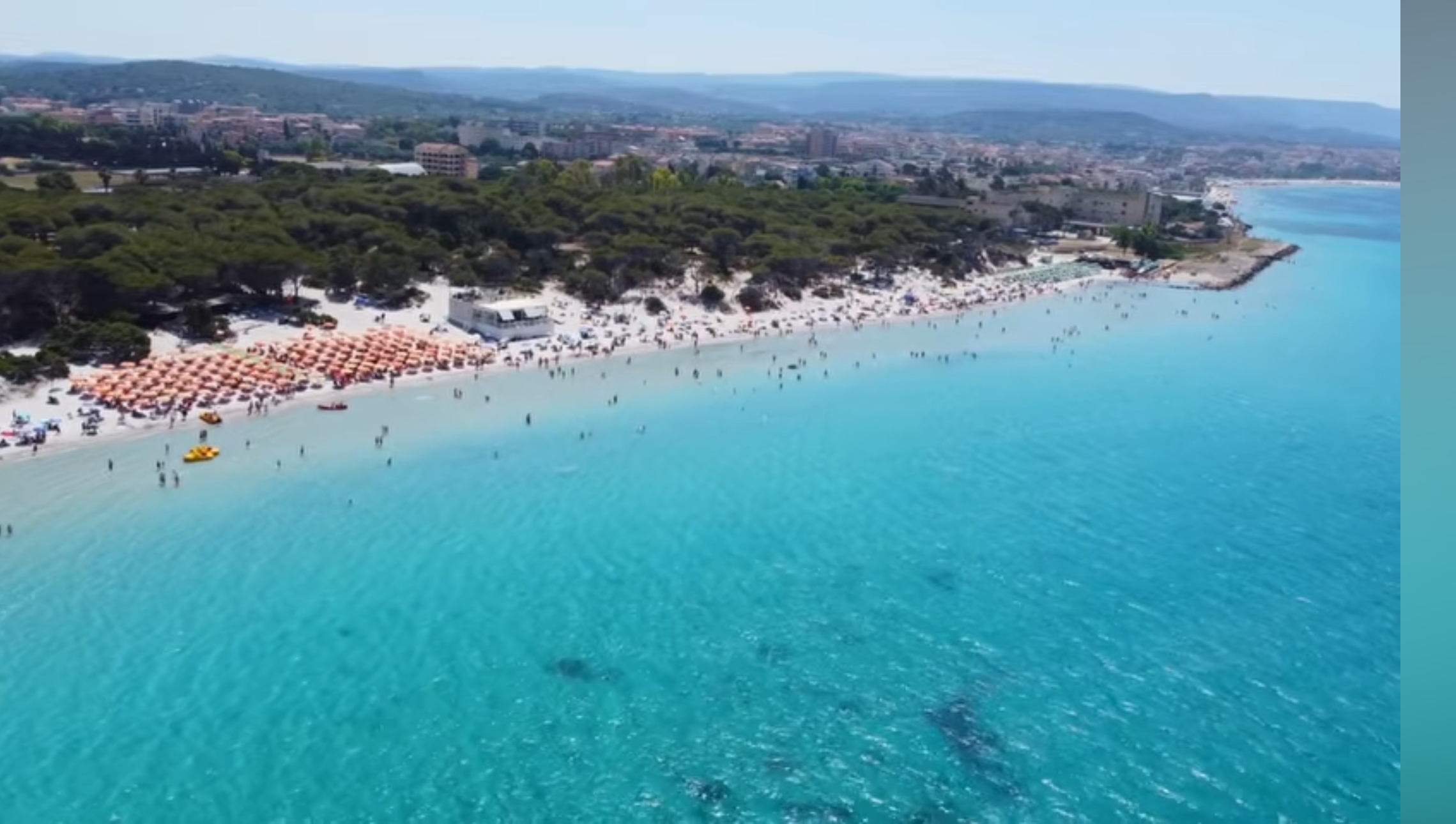Sandy beach and clear water along the Alghero coastline