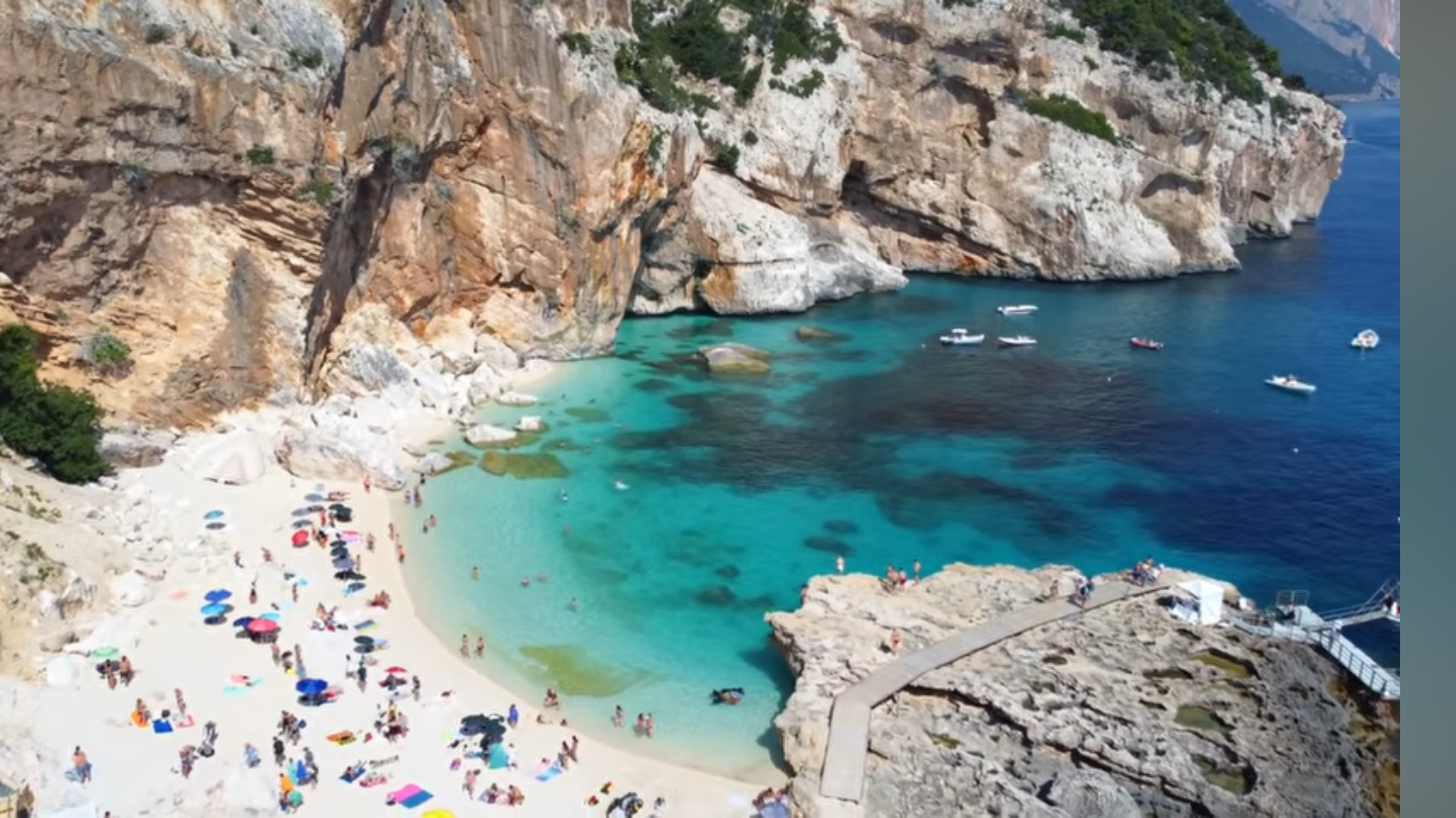 Cala Mariolu beach with a pale shoreline, turquoise water and limestone cliffs on the Baunei coast