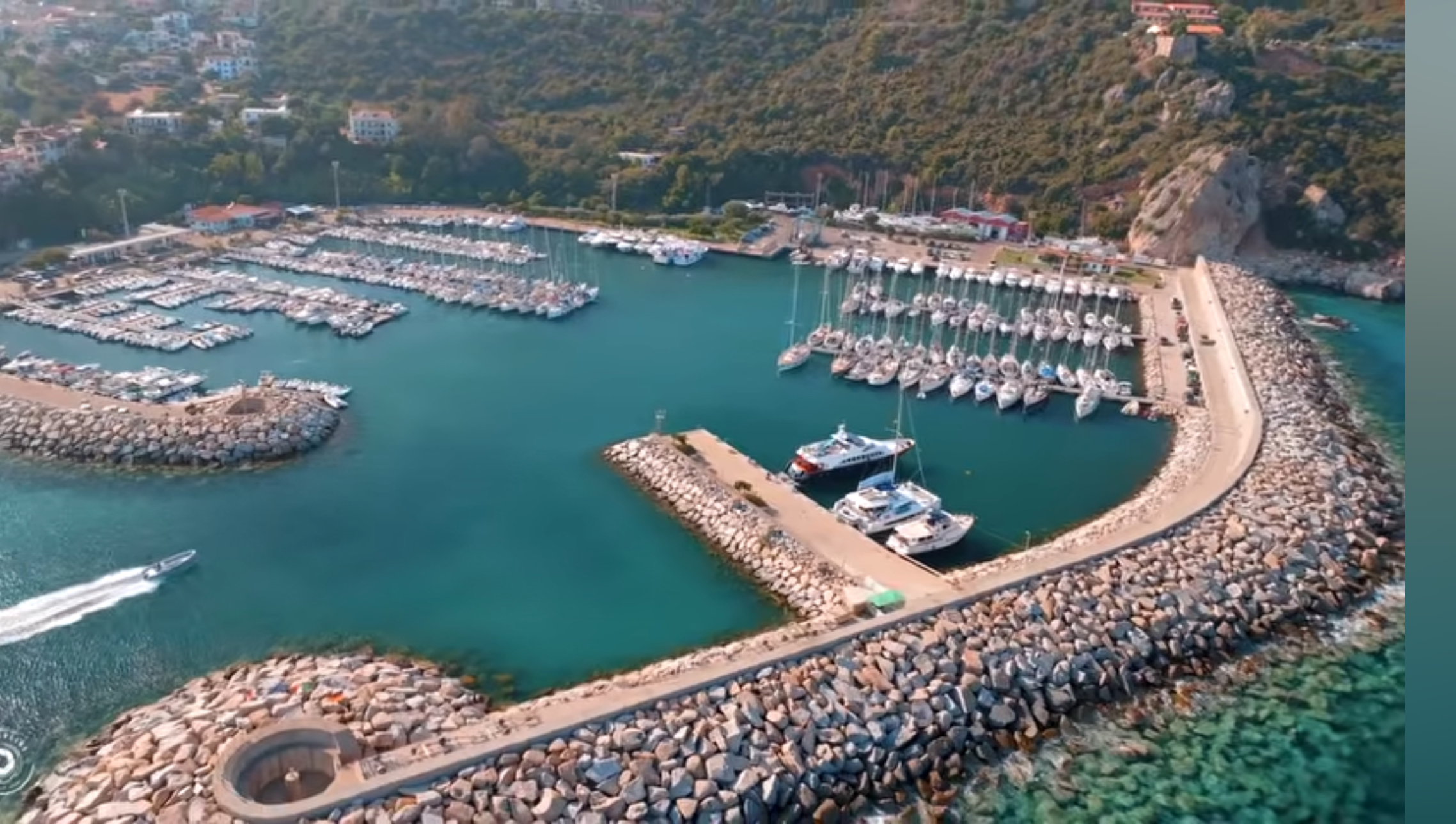 Aerial view of the marina at Santa Maria Navarrese with sailboats, excursion boats and protective breakwaters