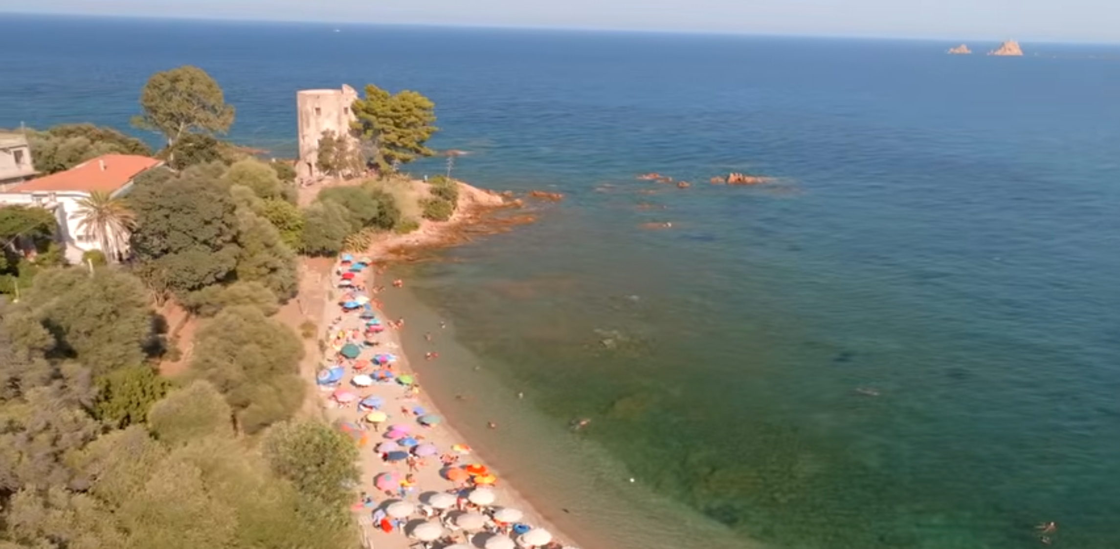 Aerial view of Santa Maria Navarrese beach, coastal tower and clear Mediterranean water